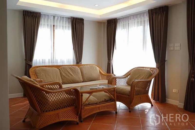 บ้าน ให้เช่าในWang Thonglang, Bangkok - ห้องนั่งเล่นสว่างด้วยชุดโซฟาหวาย โต๊ะกลาง และผ้าม่านบานใหญ่