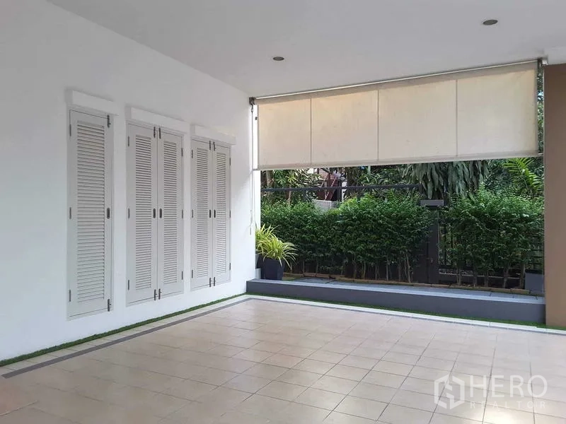 Detached House for rent in Lam Luk Ka, Pathum Thani - Covered terrace or carport with white louvered doors and a roll-down shade.
