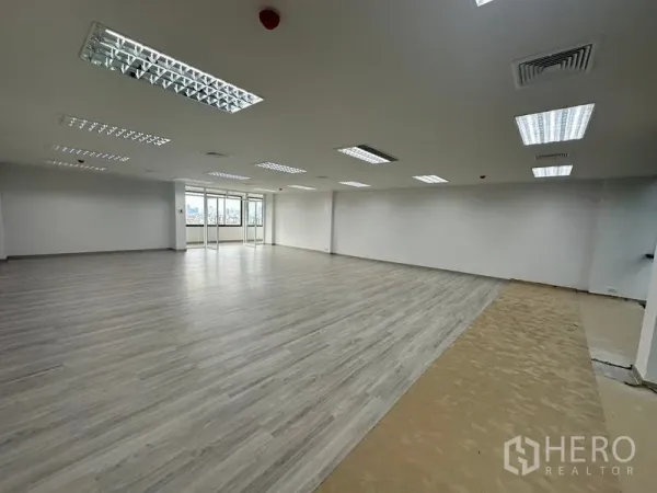 Office Space for rent - Open-plan 105 sqm office with LED lighting, vinyl floors, white walls and city-view windows near MRT Huai Khwang