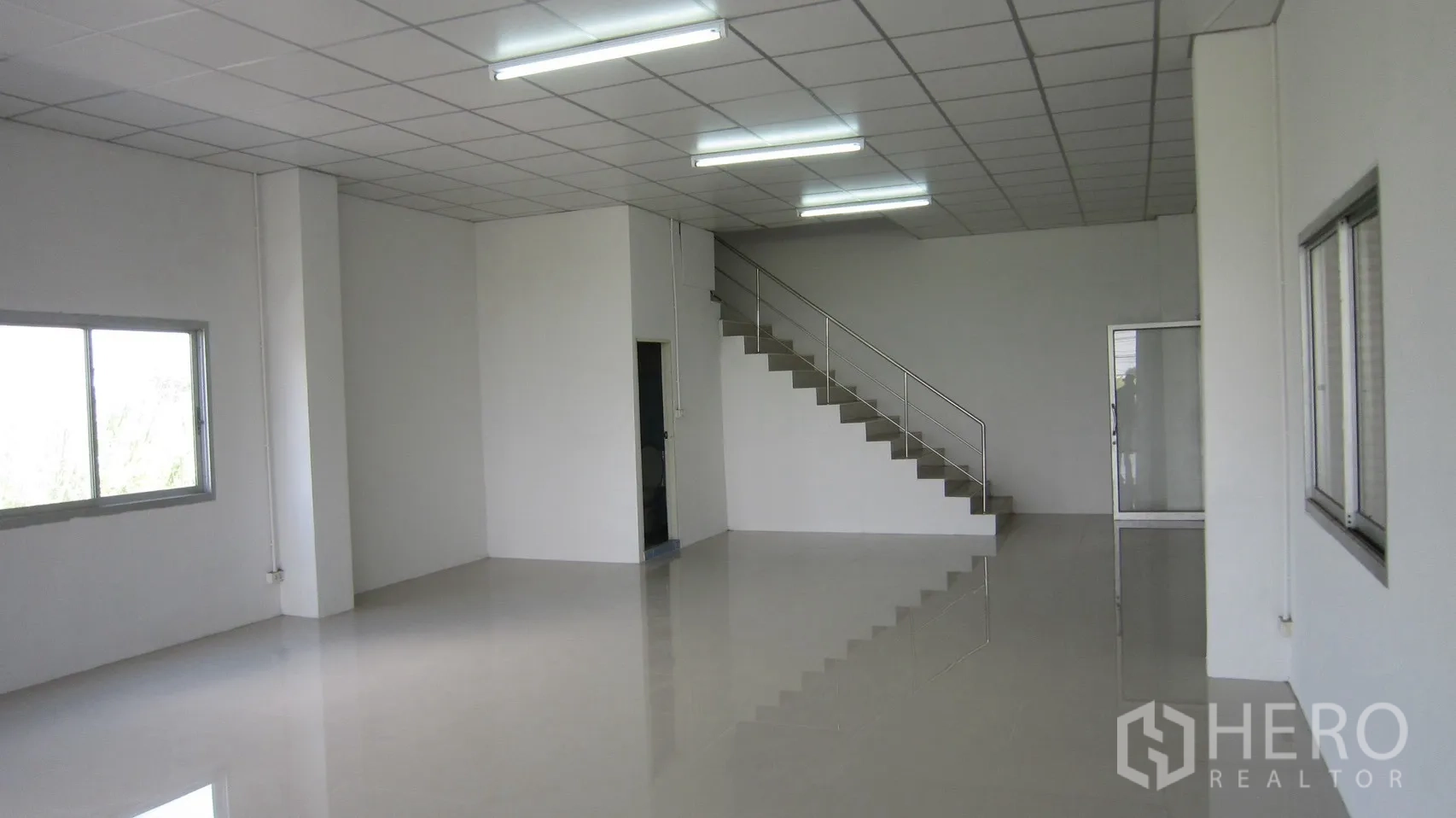 仓库 for rent in Bang Sao Thong, Samut Prakan - 仓库内一层办公室区域，设楼梯、窗户与日光灯。