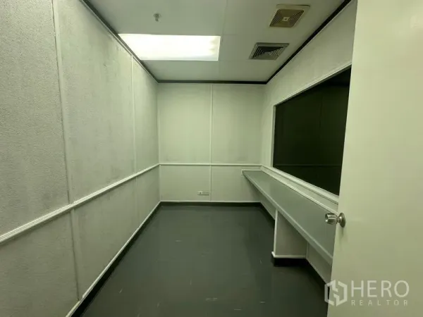 办公空间 出租在Yan Nawa, Bangkok - 紧凑型内部办公室，带长条内置操作台、传递窗口与荧光顶灯。