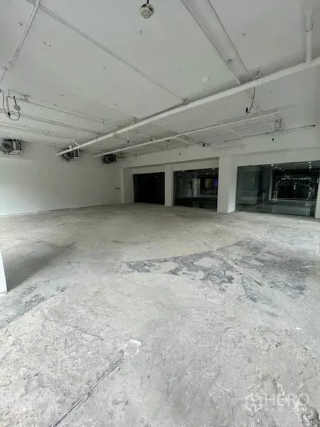 零售空间 出租在Watthana, Bangkok - 宽敞白盒子空间，外露天花管线、水泥地面与转角玻璃窗。