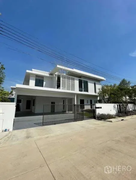 独立式住宅 出租在Samut Prakan - 正立面与电动门庭院的现代独栋住宅。