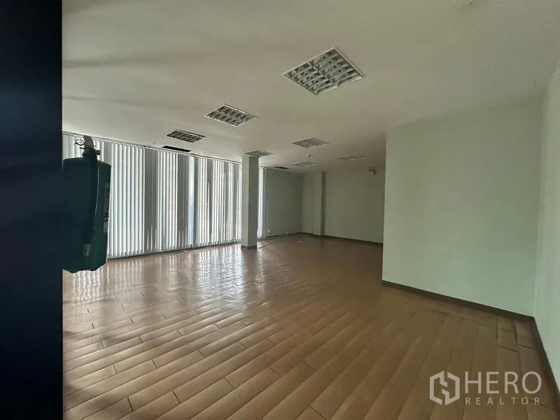Warehouse for rent in Prawet, Bangkok - Office area with floor-to-ceiling vertical blinds and wood-look tiles.
