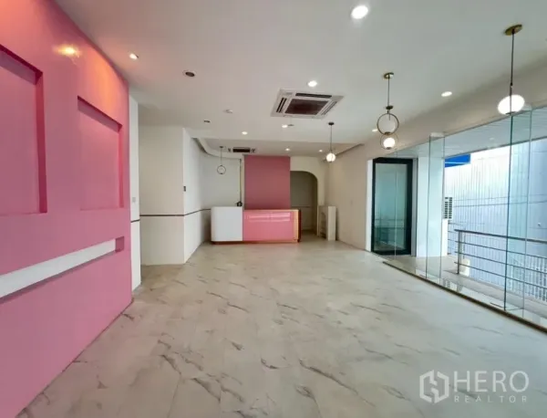Retail Space for rent in Watthana, Bangkok - Bright retail space with marble-look floors, pink feature wall, glass frontage and pendant lighting.