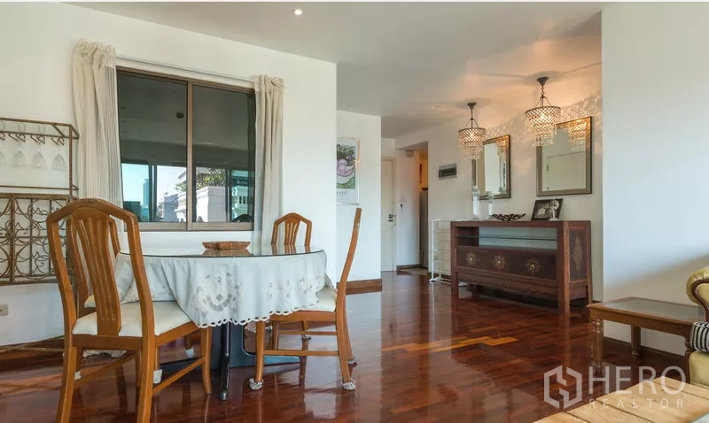 Detached House for rent in Phra Khanong, Bangkok - Dining area with chandelier lighting, wooden furniture and polished floor.