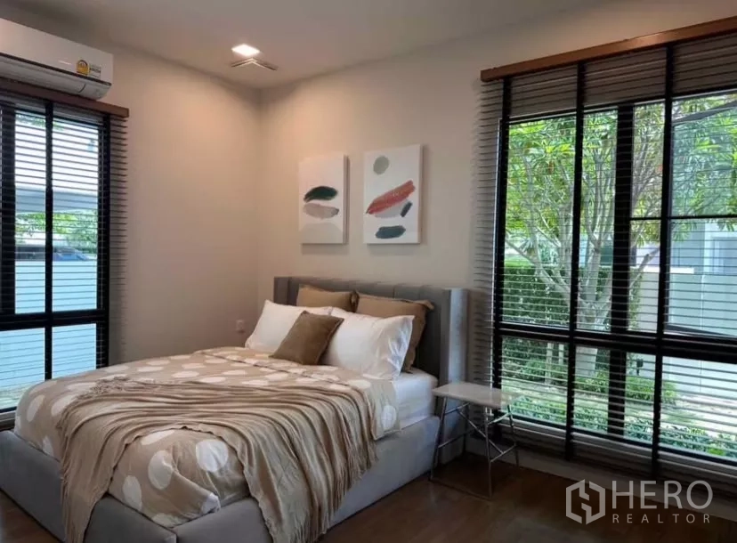 Detached House for rent in Samut Prakan - Guest bedroom with big windows, blinds, and soft-toned bedding.