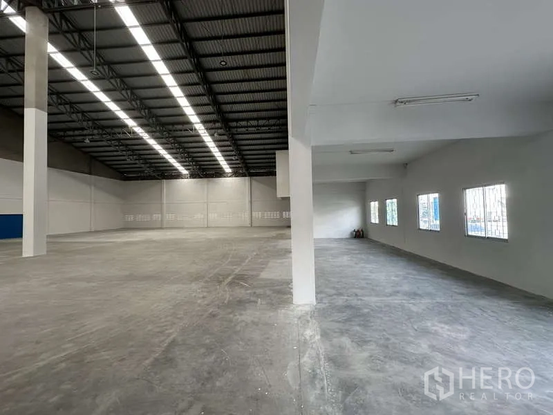 工厂 出租在Khlong Luang, Pathum Thani - 仓库连通一层办公室区域，窗户带护栏，旁为开阔作业面。