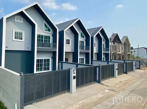 Factory for rent or sale in Bang Bua Thong, Nonthaburi - Row of modern factory units with steep gable roofs and secure front fences.