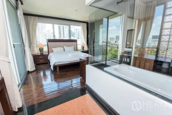 公寓 出租在Sathon, Bangkok - 主卧木地板，玻璃隔断浴室带浴缸，可眺望天际线。