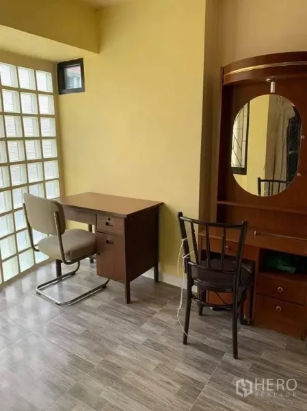 Townhouse for rent in Phra Khanong, Bangkok - Work and vanity area with wooden dressing table and desk next to a glass-block feature wall.