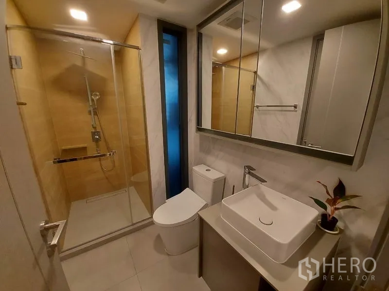 公寓 出租或出售在Watthana, Bangkok - 现代浴室，玻璃淋浴间、台上盆与镜柜一体。