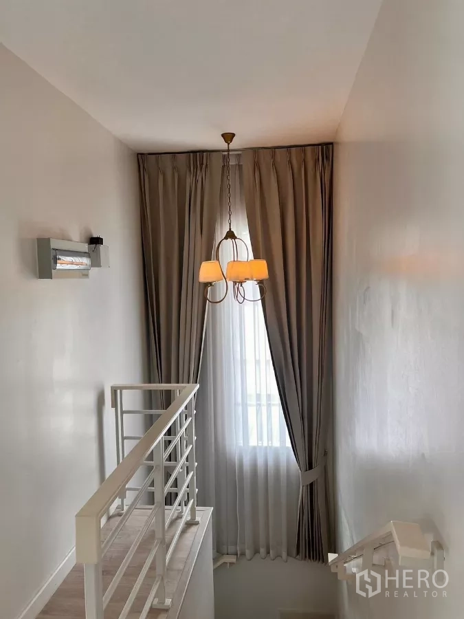 独立式住宅 出租在Lat Krabang, Bangkok - 楼梯平台配吊灯与高帘。