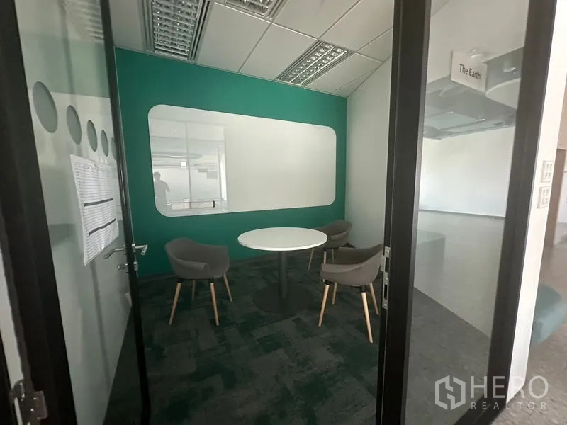 Office Space for rent in Ratchathewi, Bangkok - Compact meeting room with round table and green accent wall.