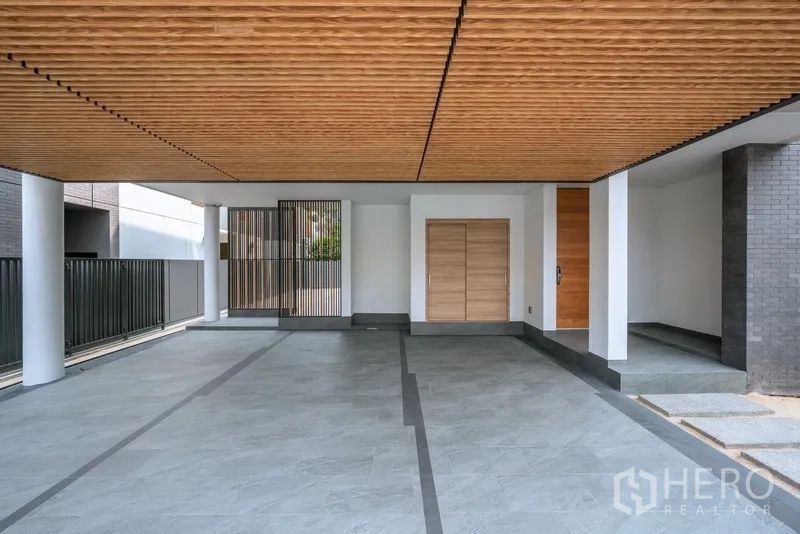 Detached House for rent or sale in Yan Nawa, Bangkok - Covered carport with wood slat ceiling and wide tiled driveway.