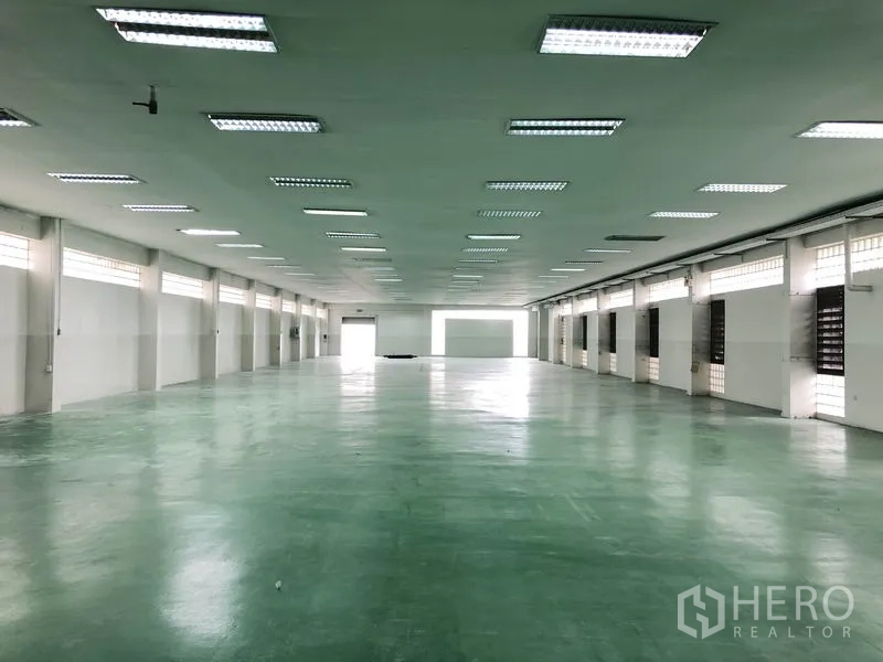 工厂 出租在Lat Krabang, Bangkok - 工厂内部空间开阔，绿色环氧地面与多扇窗户