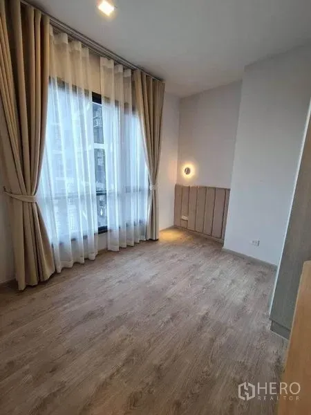 Condominium for rent - Bright bedroom with floor-to-ceiling window, sheer curtains and warm wood flooring.