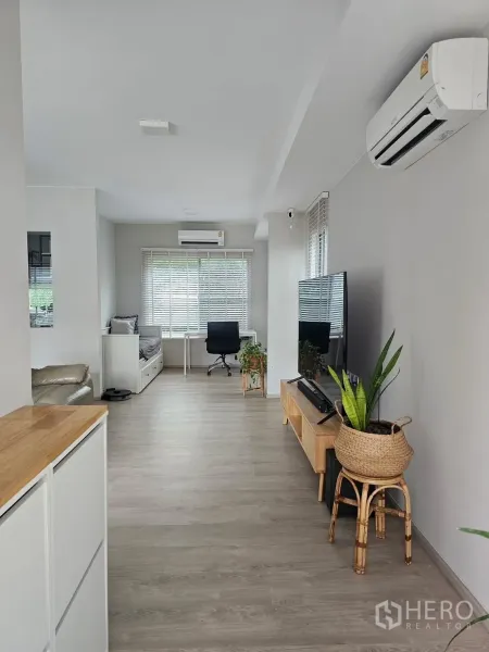 独立式住宅 出租在Prawet, Bangkok - 采光明亮的客厅，电视柜、书桌与木纹地板