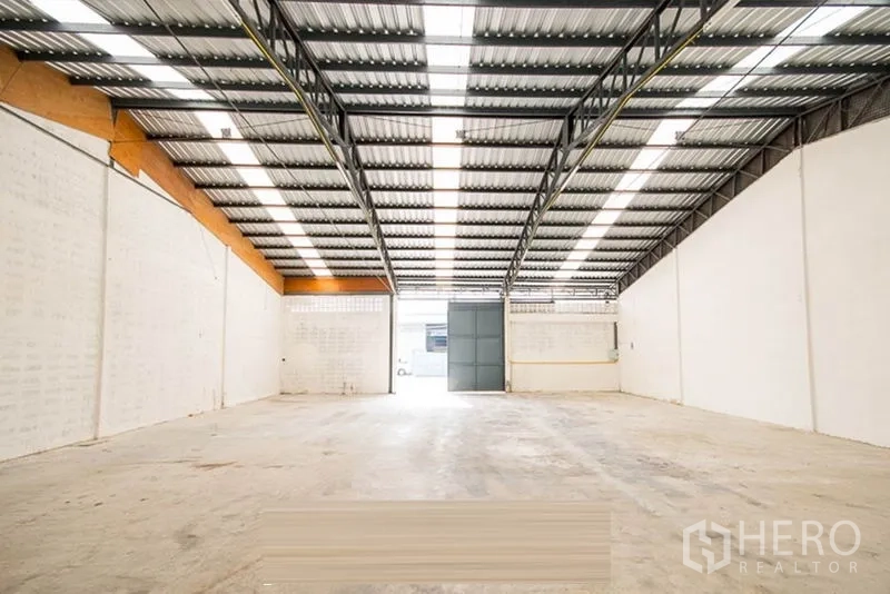 Warehouse for rent - Clean empty warehouse hall with overhead lighting and polished concrete floor.