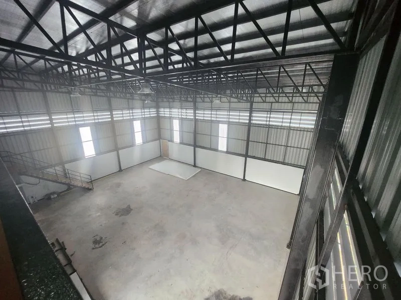 Warehouse for rent or sale in Lam Luk Ka, Pathum Thani - Spacious warehouse interior featuring a 6m-high PU-insulated steel truss roof and tall vertical windows.