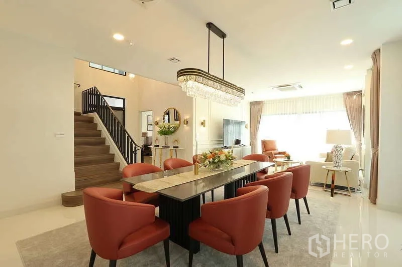 Detached House for rent in Saphan Sung, Bangkok - Open-plan living and dining space with chandelier lighting and staircase.