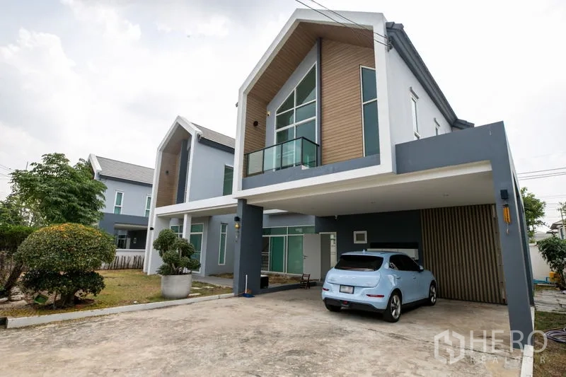 Detached House for rent or sale in Lam Luk Ka, Pathum Thani - Front facade with carport, balcony and modern gable cladding.