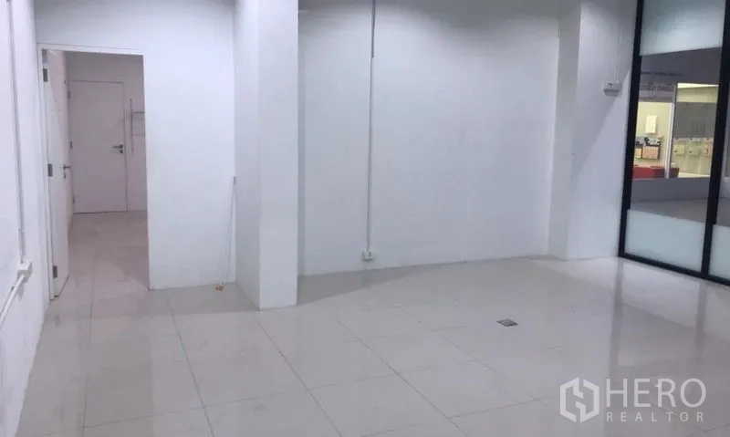 办公空间 出租在Watthana, Bangkok - 宽敞白墙办公室，瓷砖地面与玻璃隔断，适合设置工位。
