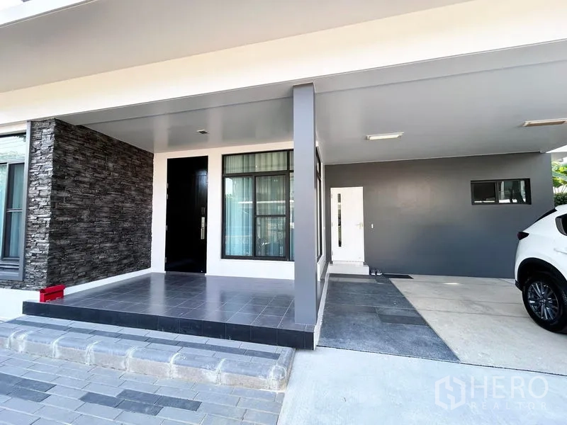 บ้าน ให้เช่าหรือขายในPrawet, Bangkok - ที่จอดรถมีหลังคาและทางเข้าบ้าน ผนังตกแต่งหิน