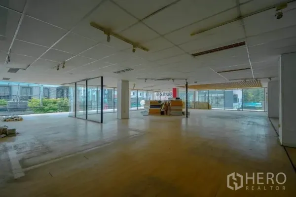 Retail Space for rent in Watthana, Bangkok - Spacious retail hall with glass walls, track lighting and views to a landscaped terrace.