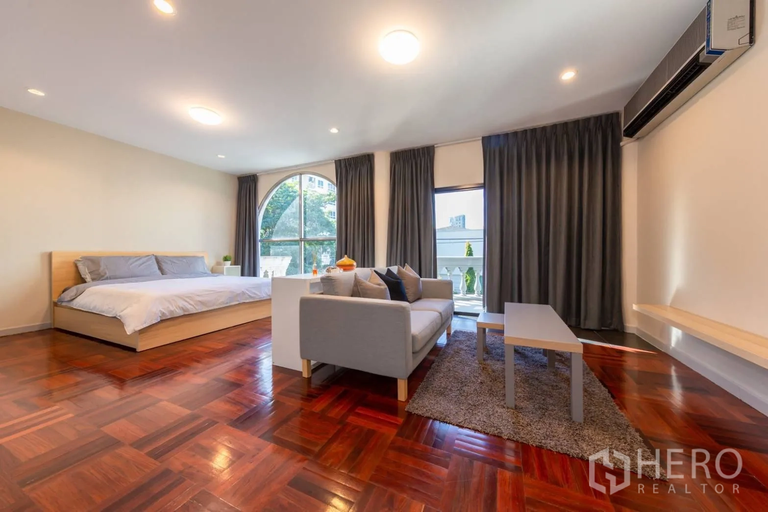 Home Office for rent in Bang Rak, Bangkok - Master bedroom showing seating area and balcony access through full-height glass.
