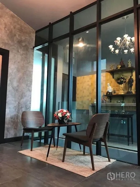 办公空间 出租在Bang Kapi, Bangkok - 等候角，双椅与小茶几，旁为玻璃隔间与吊灯。