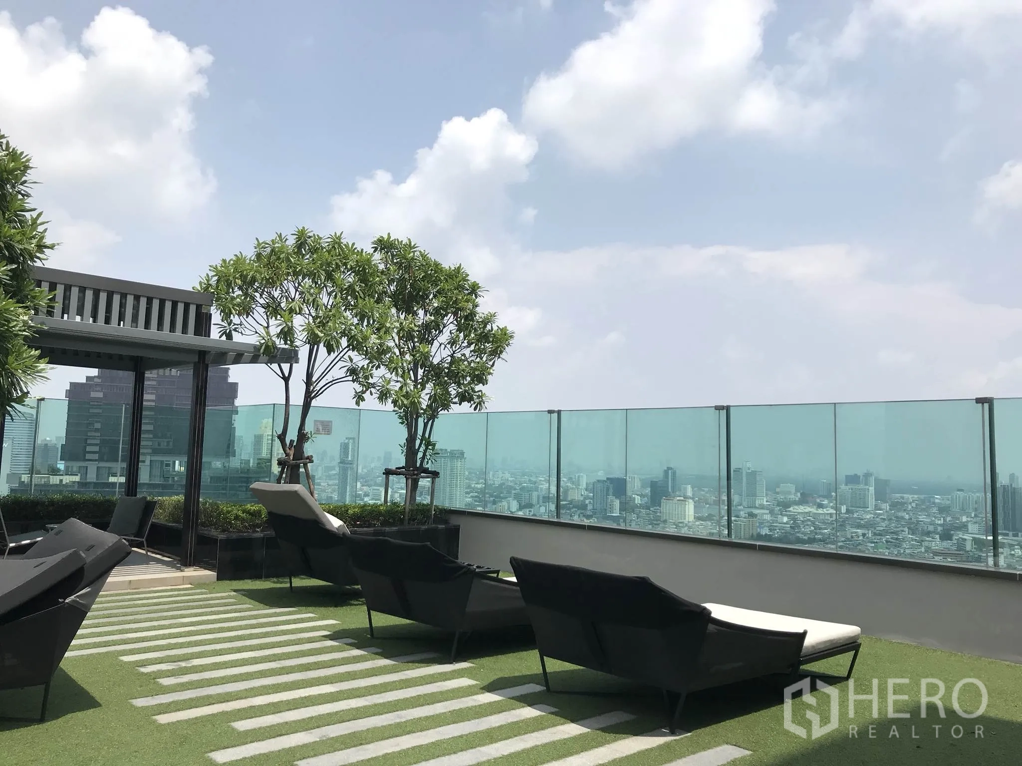 公寓 出租或出售在Sathon, Bangkok - 空中花园休闲区，躺椅与绿植，玻璃护栏面向曼谷全景。
