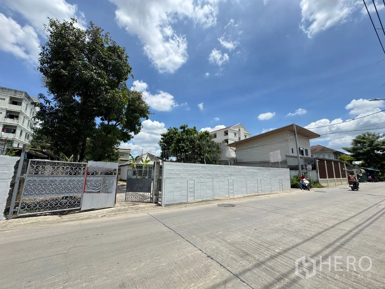 独栋房屋 for rent in Mueang Samut Prakan, Samut Prakan - 街景视角下可见房产的大门与围墙，位于住宅区内。