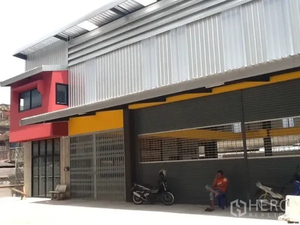 Warehouse for rent in Bang Kapi, Bangkok - Contemporary warehouse frontage with large shutters and a sheltered apron for parking.