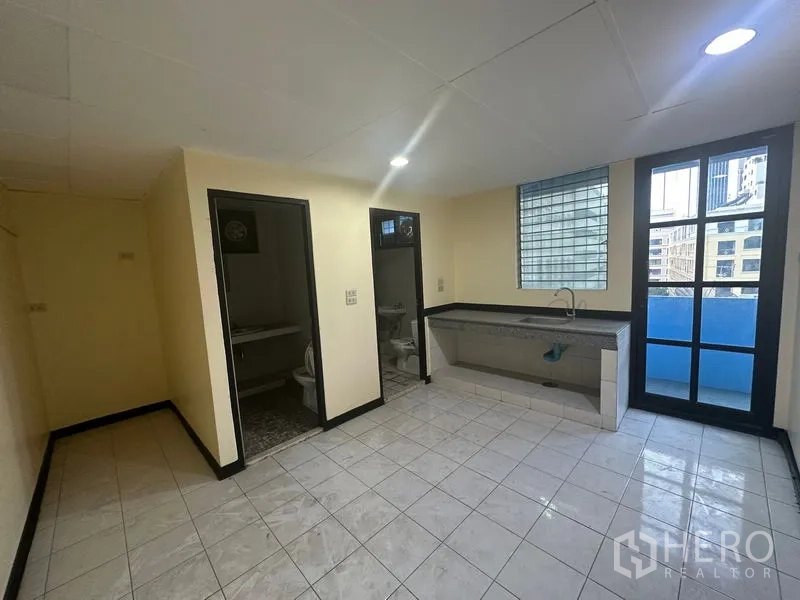 Office Space for rent in Bang Rak, Bangkok - Pantry area with long sink, two restrooms and a door leading to a small balcony.