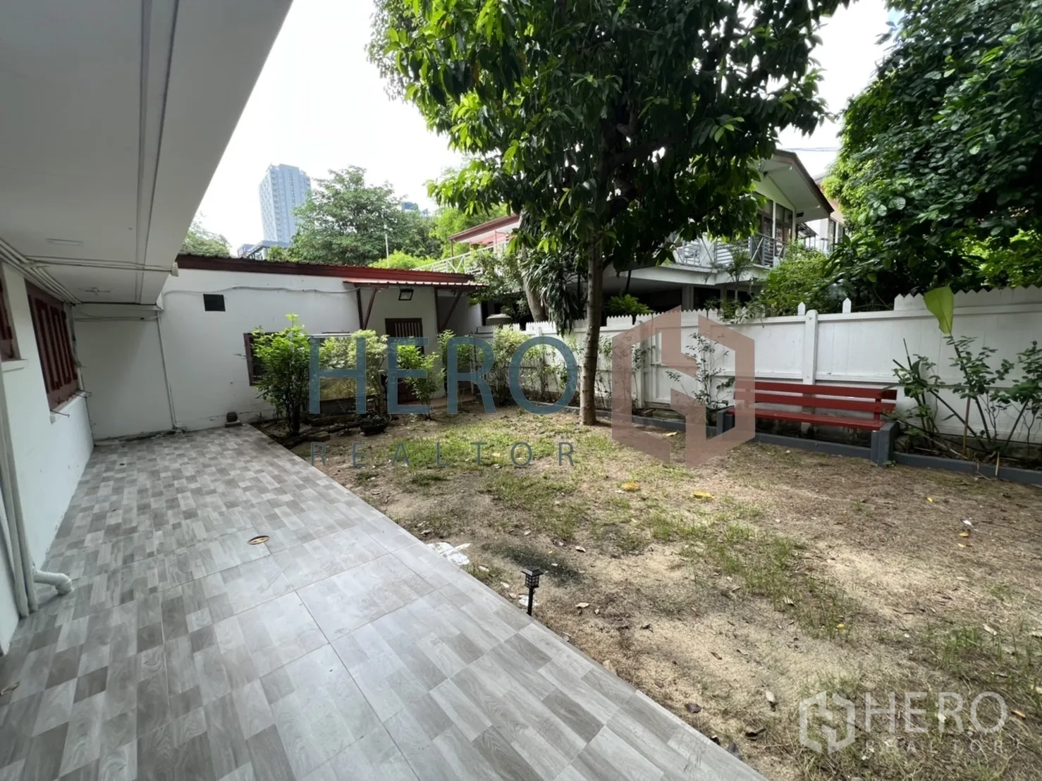 独立式住宅 出租在Watthana, Bangkok - 围篱后院，成树、长椅与草地