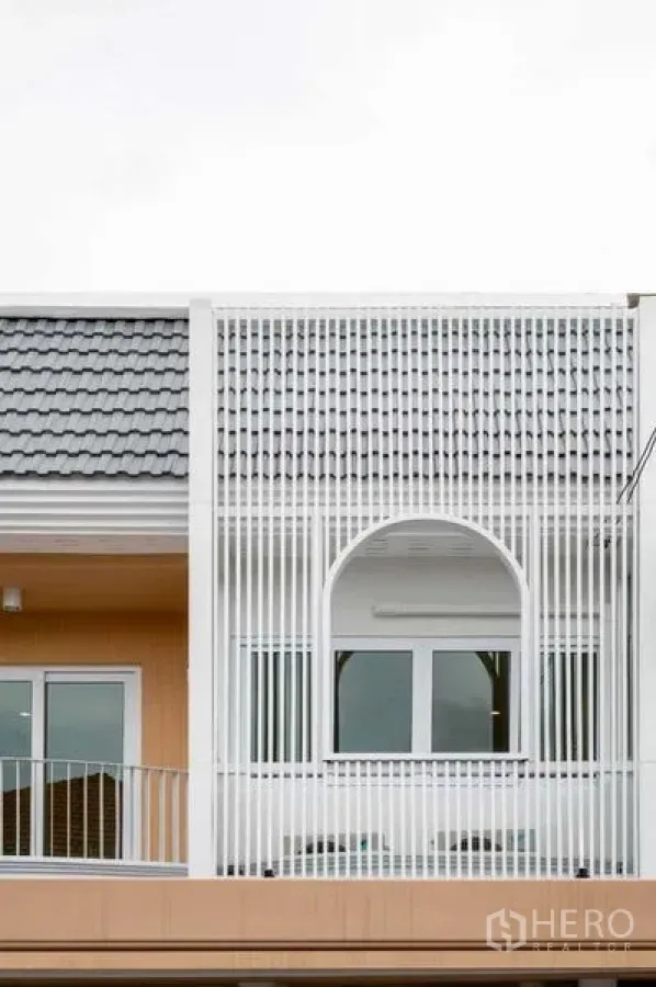 Townhouse for sale in Khlong Toei, Bangkok - Modern townhouse exterior in Phra Khanong, Bangkok with white vertical screen and arched window.