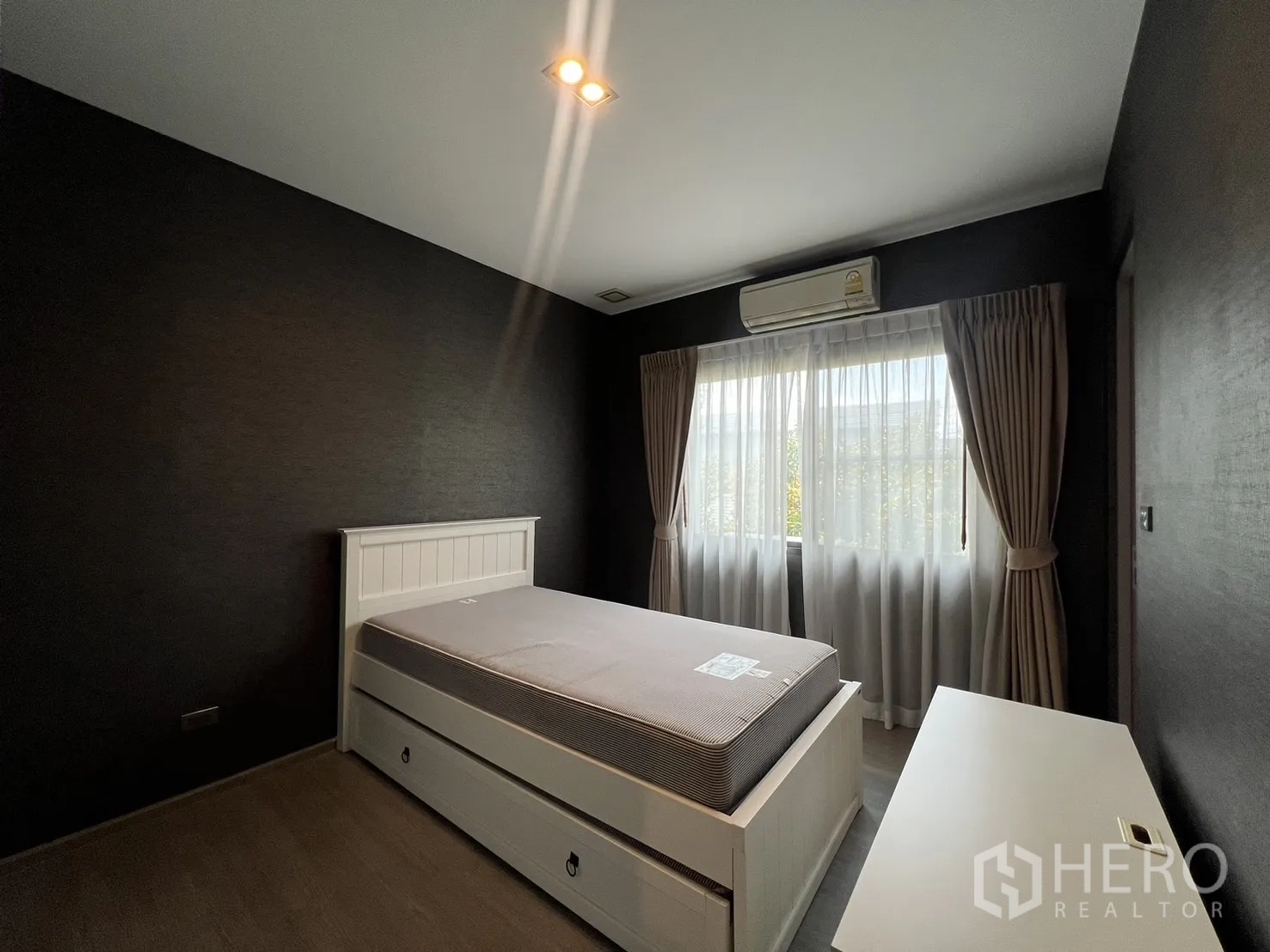 Townhouse for rent in Lat Phrao, Bangkok - Another view of guest bedroom with natural light and split-type air conditioner.