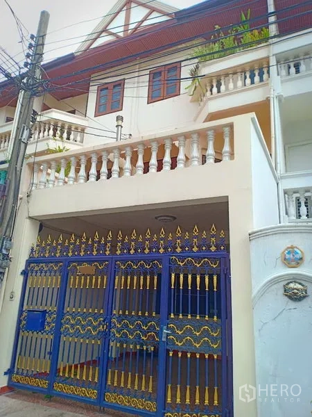 Townhouse for rent in Phra Khanong, Bangkok - Three-storey townhouse exterior with balconies and an ornate blue-and-gold gate in Bang Chak, Bangkok.