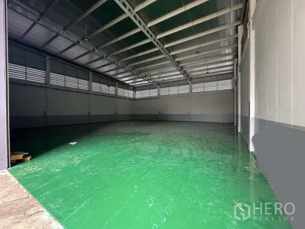 工厂 出租在Lam Luk Ka, Pathum Thani - 宽敞仓库内部，高钢结构屋顶与绿色环氧地坪