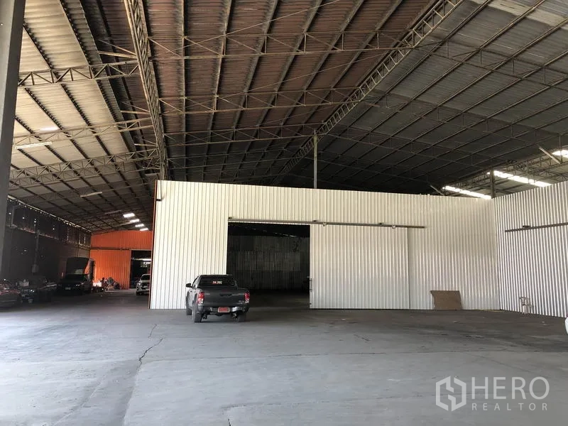 货栈 出租在Nong Chok, Bangkok - 宽敞仓库内部，高钢结构屋顶与金属波纹板隔墙，混凝土地面适合装卸车辆通行。