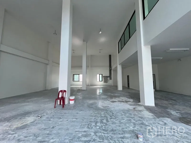Warehouse for rent in Bang Sao Thong, Samut Prakan - Clear-span warehouse interior with structural columns and a mezzanine overlooking the main floor.