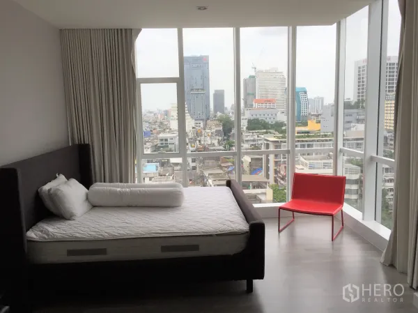 Condominium for rent in Bang Rak, Bangkok - Corner bedroom with panoramic floor-to-ceiling windows overlooking the Silom skyline.