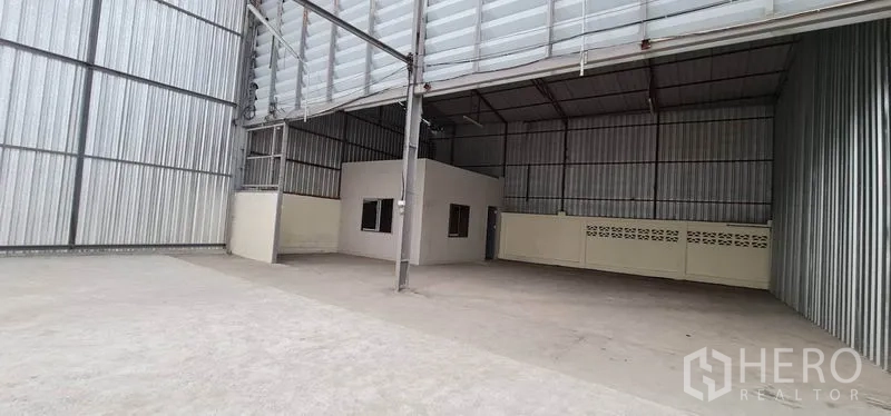 货栈 出租在Pak Kret, Nonthaburi - 仓库内部高挑通透，混凝土地面，内置办公室小间。
