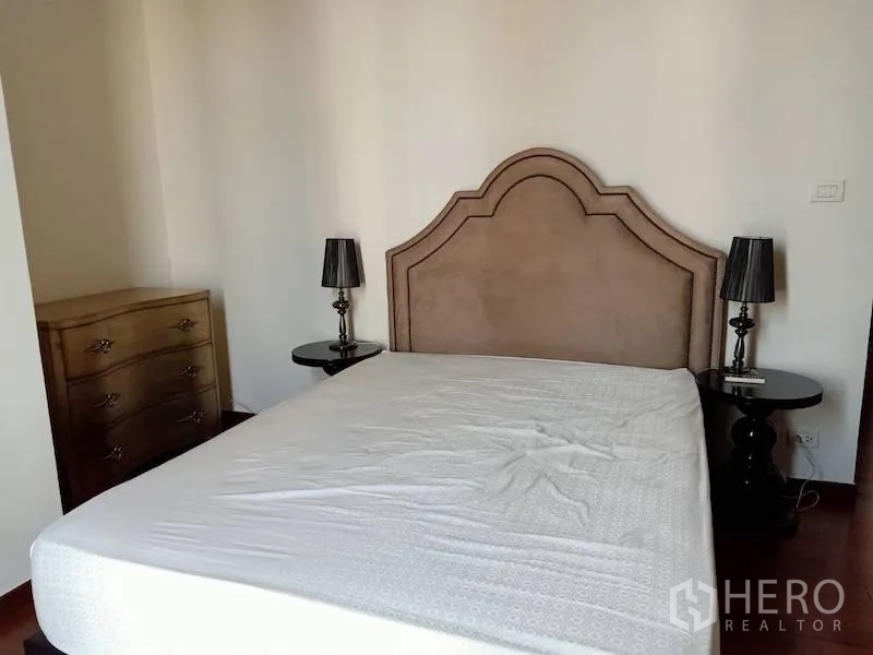 Condominium for rent in Khlong Toei, Bangkok - Master bedroom with upholstered headboard, twin bedside lamps and a dresser.