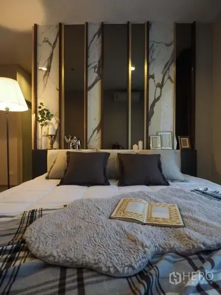 Condominium for rent in Khlong San, Bangkok - Master bedroom featuring marble-accent headboard, pillows, and a throw on the neatly made bed.