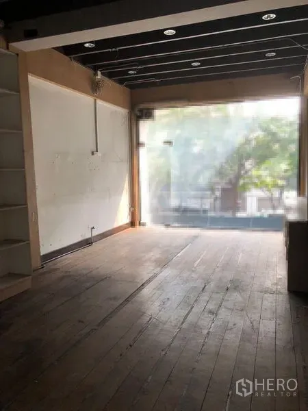 Shophouse for rent - Ground-floor retail space with timber flooring, large frosted glass shopfront and ceiling spotlights.
