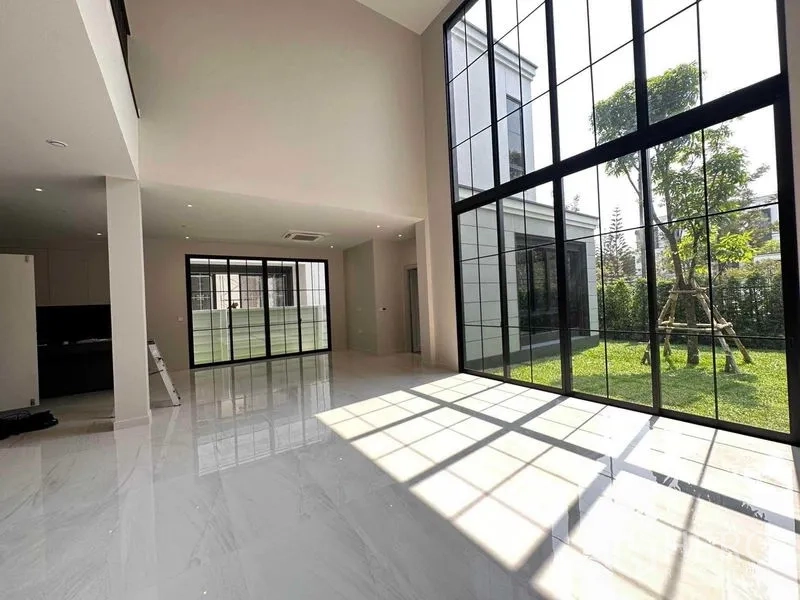 Detached House for sale in Saphan Sung, Bangkok - Bright double-height living area with expansive grid-frame windows opening to the garden.