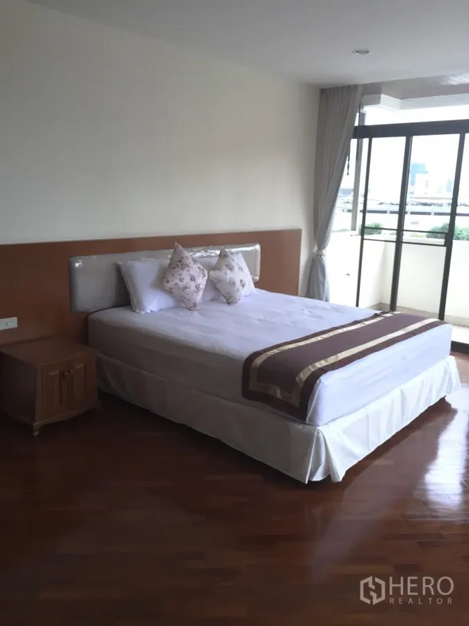 公寓 出租在Khlong Toei, Bangkok - 主卧配实木地板并通往阳台，位于Ruamsuk公寓Khlong Toei