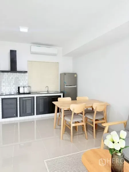 联排别墅 出租在Bang Phli, Samut Prakan - 一体厨房，黑色柜体、地铁砖背墙，配餐桌。
